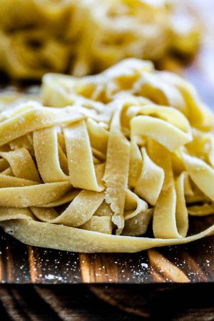 Homemade-Pasta-Recipe-Fettuccine-Linguine-Spaghetti-Sip-Bite-Go-fresh-pasta-noodles-on-a-cutting-board-feature